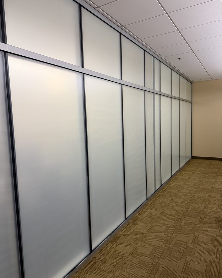 After: the same glass partitions covered in Solyx decorative frost film, still letting light through