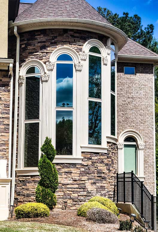 Arched residential windows treated with 3M window film on a Georgia home