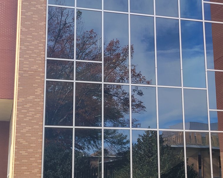 Solar control film on a commercial curtain wall reflecting the sky in Metro Atlanta